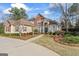 Attractive brick home featuring a lush lawn, mature trees, and a curving driveway at 612 Champions Dr, Mcdonough, GA 30253