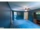 Bedroom with attached bathroom and shelving unit, featuring dark blue walls and a ceiling fan at 6214 Crestview Se Dr, Covington, GA 30014