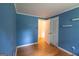 Blue bedroom featuring hardwood floors, minimalist decor, and access to an adjacent room at 6214 Crestview Se Dr, Covington, GA 30014
