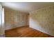 Bright bedroom with floral wallpaper, hardwood floors, and closet with louvered doors at 6214 Crestview Se Dr, Covington, GA 30014
