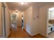 Long hallway featuring hardwood floors and neutral walls, leading to various rooms in the home at 6214 Crestview Se Dr, Covington, GA 30014