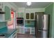 Kitchen with stainless steel refrigerator, tile floors and green cabinets at 6214 Crestview Se Dr, Covington, GA 30014