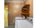 Laundry room with washer and dryer, wood-paneled walls, and access to another room at 6214 Crestview Se Dr, Covington, GA 30014