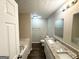 Bathroom featuring double vanity with granite countertops and a tub and shower at 9124 Comstock Ct, Covington, GA 30014