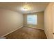 Cozy bedroom featuring neutral walls, plush carpeting, a window, and a ceiling light at 9124 Comstock Ct, Covington, GA 30014