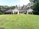 Charming ranch-style home featuring a well-manicured lawn, gray siding, black shutters, and a welcoming red front door at 9124 Comstock Ct, Covington, GA 30014