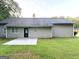 Rear exterior with a patio, grey siding, a well maintained lawn, and a black door at 9124 Comstock Ct, Covington, GA 30014