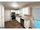 Bright kitchen featuring granite countertops, stainless steel appliances, white cabinetry and wood-look vinyl flooring at 9124 Comstock Ct, Covington, GA 30014