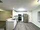 Modern kitchen featuring stainless steel appliances, white cabinets, and durable gray laminate flooring at 408 Kendall Ln, Mcdonough, GA 30253