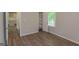 An empty room showcasing wood floors, a built-in closet, and a hallway leading to the kitchen at 525 Baker Nw Cir, Atlanta, GA 30318