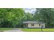 A single-story house with a well-maintained lawn, mature trees, and a welcoming entrance for a peaceful setting at 525 Baker Nw Cir, Atlanta, GA 30318