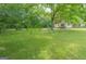 A beautiful lawn stretches to the home's welcoming porch, surrounded by mature trees and lush greenery at 525 Baker Nw Cir, Atlanta, GA 30318