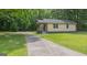 A single-story home surrounded by a beautiful lawn and mature trees, complete with a long driveway at 525 Baker Nw Cir, Atlanta, GA 30318