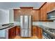 Updated kitchen with stainless steel refrigerator, granite countertops, and dark wood cabinets at 3641 Ridge Towne Dr, Duluth, GA 30096