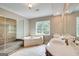 Bright main bathroom with dual sinks, large mirrors, a separate tub, and a glass-enclosed shower at 3641 Ridge Towne Dr, Duluth, GA 30096