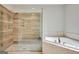 Close-up of glass shower and tub with tile surround in the main bathroom at 3641 Ridge Towne Dr, Duluth, GA 30096