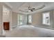 Spacious main bedroom with a ceiling fan, tray ceiling, carpeted floors, and a door to the balcony at 3641 Ridge Towne Dr, Duluth, GA 30096