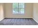 Bright bedroom with gray carpeting and a large window offering scenic views at 4411 Ward Bluff Ct, Ellenwood, GA 30294