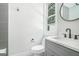 Modern bathroom featuring a sleek vanity with white countertop, gray cabinets, and a round mirror at 115 Thome, Alpharetta, GA 30022