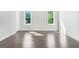 Bright bedroom featuring newly-finished hardwood floors, fresh white paint, and two large windows at 115 Thome, Alpharetta, GA 30022