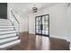 Elegant entryway features hardwood floors, staircase with glass railing, and modern lighting at 115 Thome, Alpharetta, GA 30022