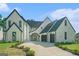 Charming two-story home with white brick, black trim, a driveway and lovely landscaping at 115 Thome, Alpharetta, GA 30022