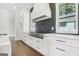 A gourmet kitchen features custom white cabinetry, black matte hardware, and stainless steel appliances at 115 Thome, Alpharetta, GA 30022