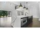 Bright open-concept living area features a large island, dark floors, and access to a patio at 115 Thome, Alpharetta, GA 30022