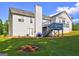 Spacious backyard featuring a well-maintained lawn, fire pit, and a two-story home with a deck and patio at 221 Ashley Trace Dr, Locust Grove, GA 30248