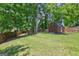 Large, grassy backyard with mature trees and storage shed provides lots of room to play at 1026 Ponderosa Park Dr, Forest Park, GA 30297