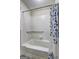 Bathroom with a tiled shower-tub combination, grab bar, and a floral shower curtain at 1026 Ponderosa Park Dr, Forest Park, GA 30297