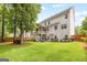 Expansive backyard featuring a two-story home with a porch, lush lawn, and mature trees at 1596 Fearn Ne Cir, Brookhaven, GA 30319