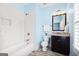Blue bathroom with a bathtub, dark wood vanity, and a white subway tile shower at 1596 Fearn Ne Cir, Brookhaven, GA 30319