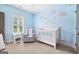 Charming Bedroom room painted blue with a crib, soft carpet, and plenty of natural light at 1596 Fearn Ne Cir, Brookhaven, GA 30319