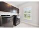 Laundry room with new washer and dryer and dark cabinets for storage at 1596 Fearn Ne Cir, Brookhaven, GA 30319
