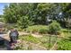 Expansive backyard boasts a garden, lush greenery, mature trees, and a patio area at 3842 Monticello St, Douglasville, GA 30135