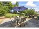 Backyard brick patio area with table, chairs and umbrella for outside enjoyment at 3842 Monticello St, Douglasville, GA 30135