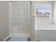 Clean bathroom featuring a shower with a curtain and a luxurious soaking tub with jets by the window at 3842 Monticello St, Douglasville, GA 30135