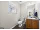 Cozy half bathroom with wood cabinets, updated fixtures, and natural light at 3842 Monticello St, Douglasville, GA 30135