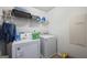 Efficient laundry room with washer, dryer, storage shelf, and wall-mounted smart connection center at 3842 Monticello St, Douglasville, GA 30135