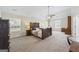 Expansive main bedroom with a tray ceiling, a ceiling fan, natural light, and ample open space at 3842 Monticello St, Douglasville, GA 30135