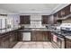 Well-equipped kitchen featuring tile flooring, dark cabinetry, and modern stainless steel appliances at 244 Timber Creek Ln, Marietta, GA 30060