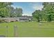Fenced backyard with a home featuring a screened in porch, a separate storage building and mature trees at 270 E James Cir, Hampton, GA 30228