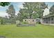 Spacious backyard featuring mature trees, a storage shed, and a glimpse of the lake at 270 E James Cir, Hampton, GA 30228