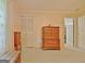 Bedroom featuring neutral carpeting, wooden dressers, closet space, and a sitting bench at 270 E James Cir, Hampton, GA 30228