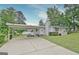 View of home from driveway featuring a carport, well-maintained lawn, and garden at 270 E James Cir, Hampton, GA 30228