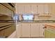 Galley style kitchen with white cabinets, green counters and black oven appliances at 270 E James Cir, Hampton, GA 30228