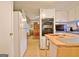 Bright kitchen offers white appliances, wooden island, and leads into the dining room at 270 E James Cir, Hampton, GA 30228