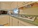 Kitchen sink and stove top with green countertops and white cabinets at 270 E James Cir, Hampton, GA 30228