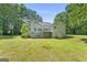Spacious backyard featuring a deck, stairs, mature trees, and lush green lawn at 40 Wenham Ln, Sharpsburg, GA 30277